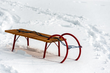 Wooden winter snow sleigh with red metal runners