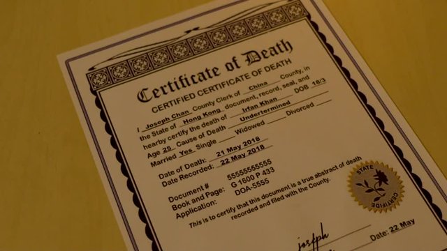 A replica death certificate paper on the table.