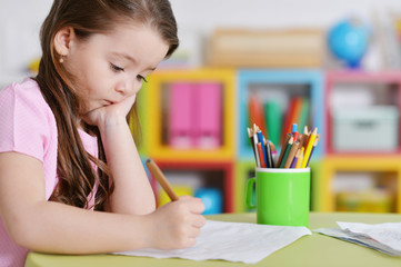 Cute little girl in pink shirt drawing