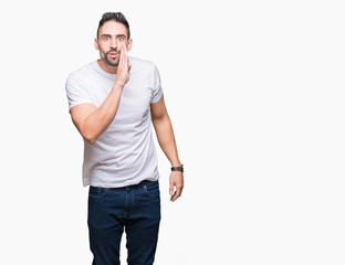 Handsome man wearing white t-shirt over white isolated background hand on mouth telling secret rumor, whispering malicious talk conversation