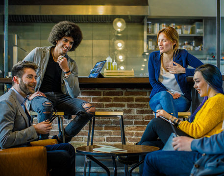 Colleagues smiling and talking together.Group of multiethnic people having business team meeting in restaurant lounge.Teamwork,corporate,diversity and social concepts. - Powered by Adobe