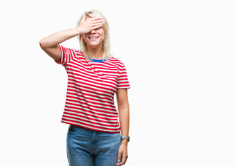 Fototapeta premium Young beautiful blonde woman over isolated background smiling and laughing with hand on face covering eyes for surprise. Blind concept.