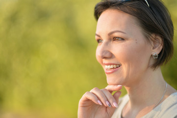 Portrait of beautiful young woman resting in summer park