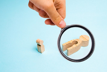 Magnifying glass is looking at the fallen wooden women with a void in the body from which the child...