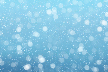 Obraz premium Snow falls on winter blue sky background