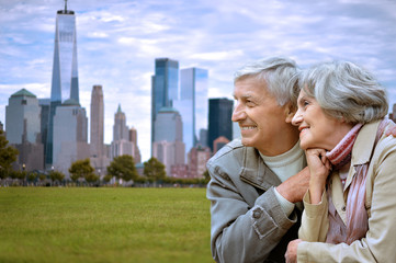 happy senior couple posing on green meadow against