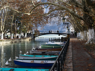 Shot of the beautiful Canal du Vassè which brings to the romantic Pont de Amours in Annecy, France. The canal is full of boats. The shot is taken in autumnal season