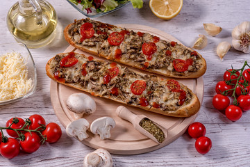 Tasty Pizza Baguette with Mushrooms and Parmesan Ingredients -paradaya, salad, garlic, oregano, olive oil on a wooden table traditional Italian food