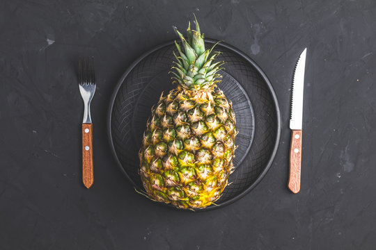 Pineapple in ceramic plate and set of cutlery knife and fork