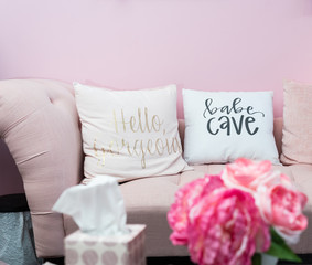 pink couch with pillows and flowers