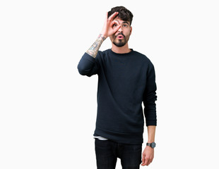 Fototapeta premium Young handsome man over isolated background doing ok gesture shocked with surprised face, eye looking through fingers. Unbelieving expression.