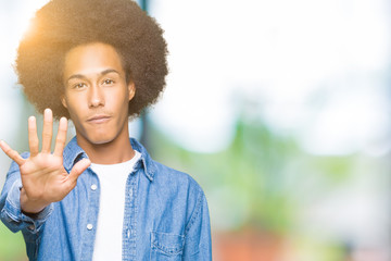 Young african american man with afro hair doing stop sing with palm of the hand. Warning expression with negative and serious gesture on the face.