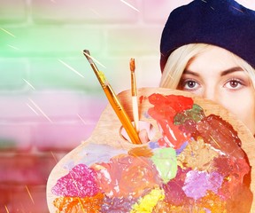 Young beautiful woman with painted  face and paintbrushes