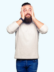 Fototapeta premium Young blond man wearing casual sweater Tired hands covering face, depression and sadness, upset and irritated for problem