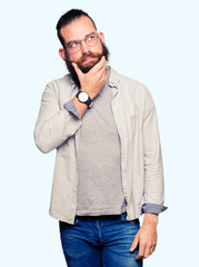 Young blond man wearing glasses thinking looking tired and bored with depression problems with crossed arms.