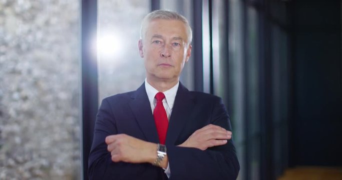 4K Portrait of serious business manager looking at camera with arms crossed