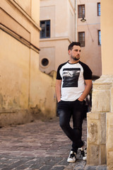 Young man in t-shirt walking in old town