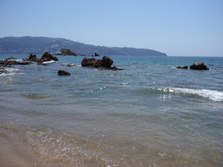 Brilliant view of rocks at bay of ACAPULCO city in Mexico with Pacific Ocean waves on sandy beach...
