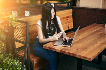 Young woman freelancer in cafe with laptop