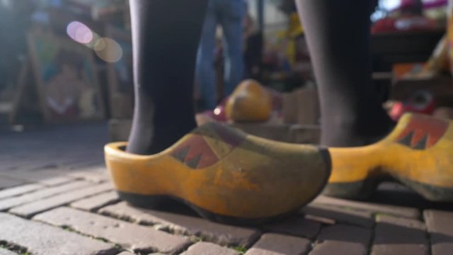 A girl walking with Dutch clogs, called "klompen" in The Netherlands, in a market in Amsterdam.