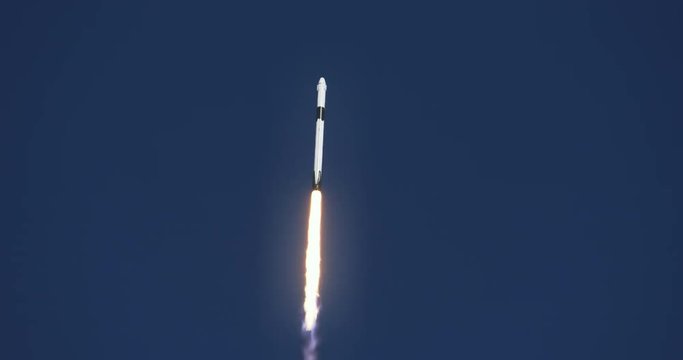 Space rocket or ICBM missile soars into space with bright trail of white smoke and exhaust in a clear blue sky.  4K at 120 fps slow motion. With audio.