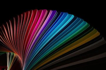 Color fan deck with samples of various paint isolated on a black background