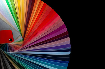 Color fan deck with samples of various paint isolated on a black background
