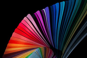Color fan deck with samples of various paint isolated on a black background