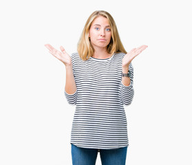 Fototapeta na wymiar Beautiful young woman wearing stripes sweater over isolated background clueless and confused expression with arms and hands raised. Doubt concept.