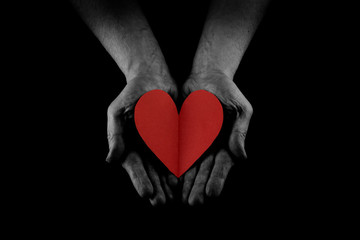 Obraz premium Helping hand concept, Man's hands palms up holding a Red Heart, giving love, care and support, reaching out