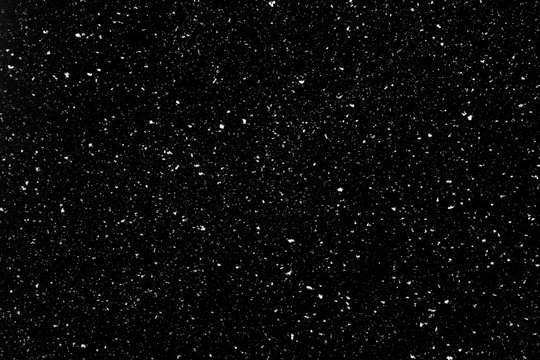 Real snow falling in a winter night. White snow on black background. Abstract elements to use in graphic design or as an overlay for other photos.