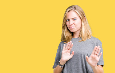 Beautiful young woman wearing oversize casual t-shirt over isolated background disgusted...