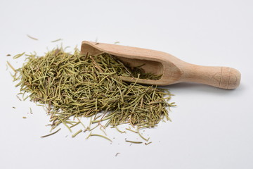 Dried rosemary on wooden scoop over white background