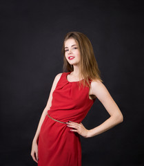 A beautiful girl in a red dress with long hair and a make-up.