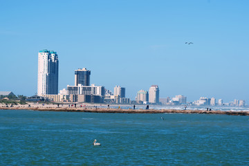 View of the skyscrapers, hotels, recreation areas of South Padre Island and the pier with fishermen a resort town on a barrier island of the same name, off the southern coast of Texas
