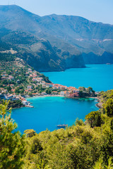 Fototapeta na wymiar Mediterranean seashore in Greece. Beautiful turquoise colored Assos bay water surrounded by pine and cypress trees. Amazing nature, must see places