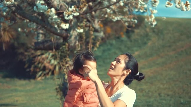 Slow motion of Asian mother carrying toddler