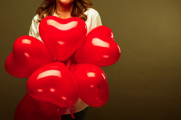 Beautiful young woman with heart shape air balloon on Black background.  Valentine's Day