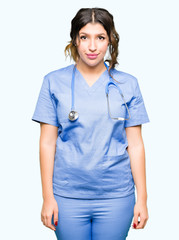 Young adult doctor woman wearing medical uniform Relaxed with serious expression on face. Simple and natural looking at the camera.