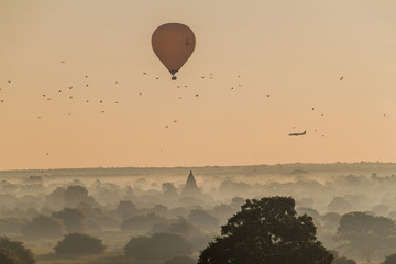 Balloon over Bagan, landing airplane and the skyline of its temples, Myanmar