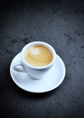 Cup of coffee on black stone background. Copy space.