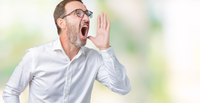 Handsome middle age elegant senior business man wearing glasses over isolated background shouting and screaming loud to side with hand on mouth. Communication concept.