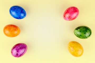 Colored Easter eggs on yellow background.