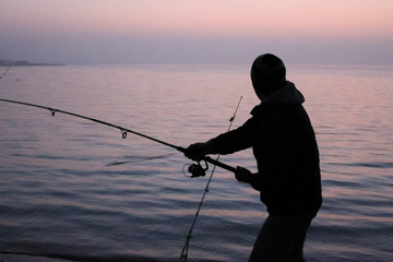 fisherman fishing in the evening on the lake