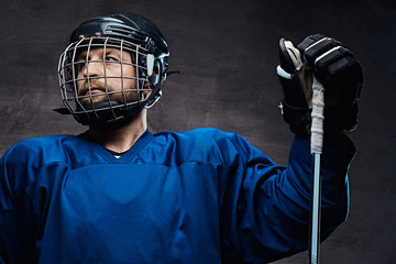 Portrait of a professional ice-hockey player in a hockey uniform. Studio shot.