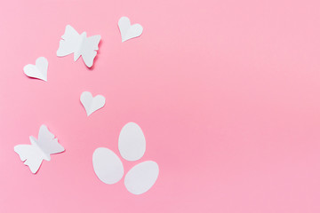 Three white easter eggs, hearts and butterflies cut of paper on pink background, easter and spring concept wiyh copy space