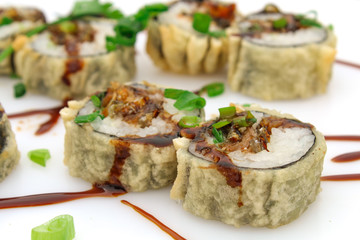 Hot fried Sushi Roll with salmon skin, chive and teriyaki. Sushi menu. Japanese food. Futomaki. Isolated on white background