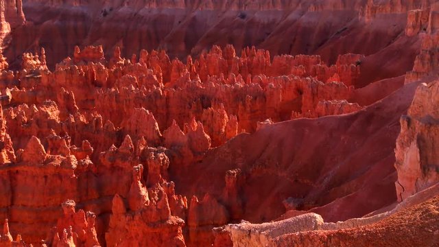 Camera pans across beautiful view of orange and red spires and hoodoos at Bryce Canyon National Park in Utah.