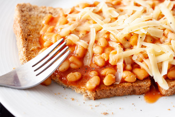 Close-up of baked beans on toast topped with grated cheese
