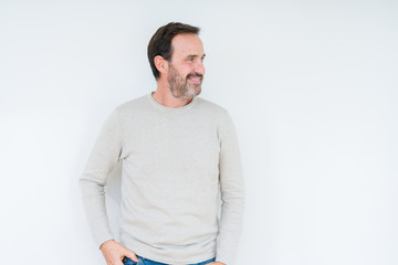 Fototapeta premium Elegant senior man over isolated background looking away to side with smile on face, natural expression. Laughing confident.